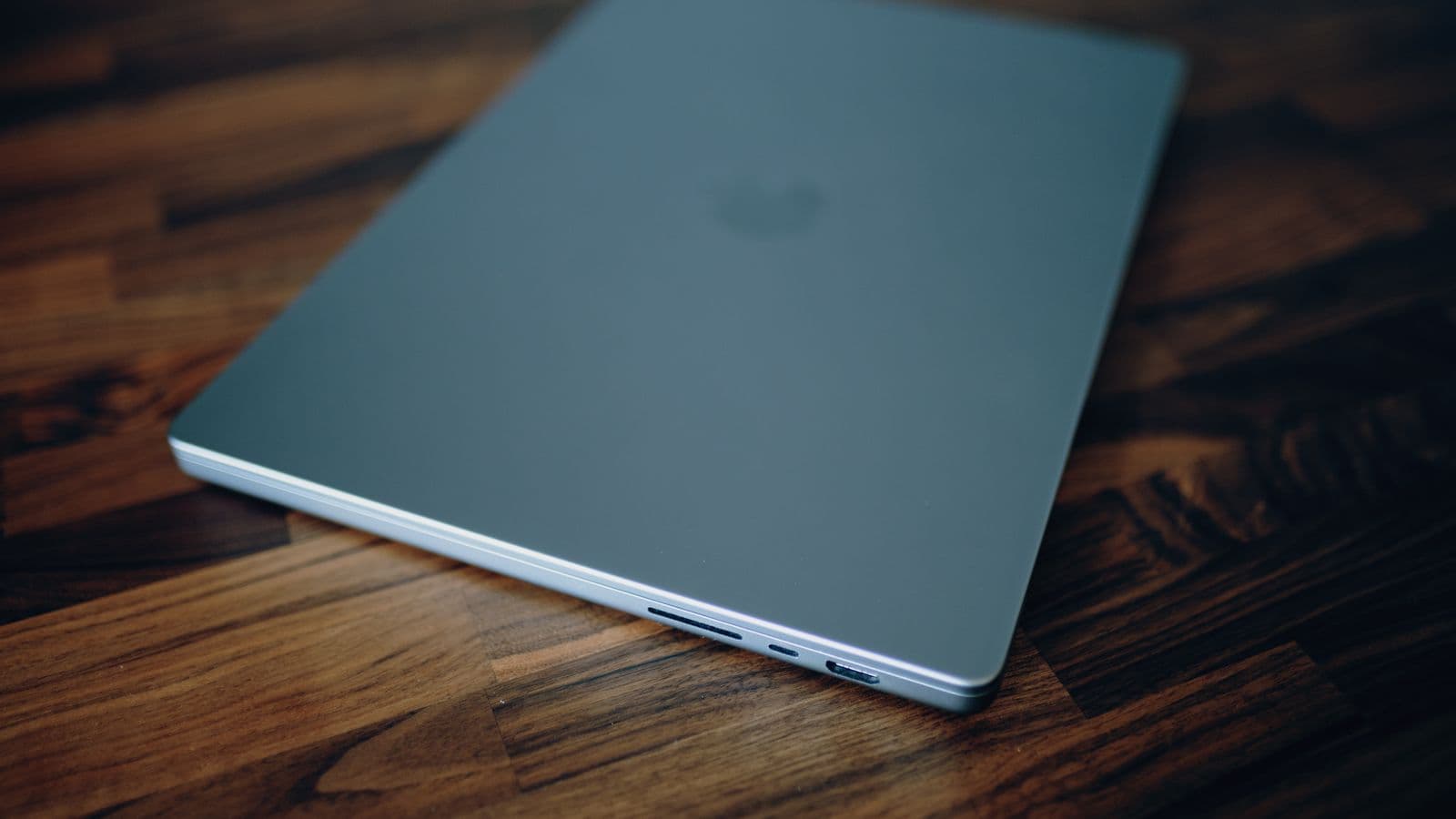 A silver MacBook on a wooden desk