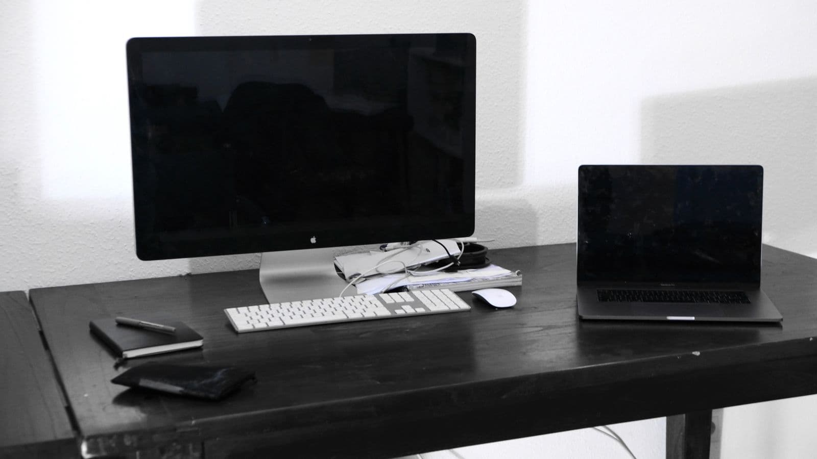 A desk with a computer and laptop set up for work