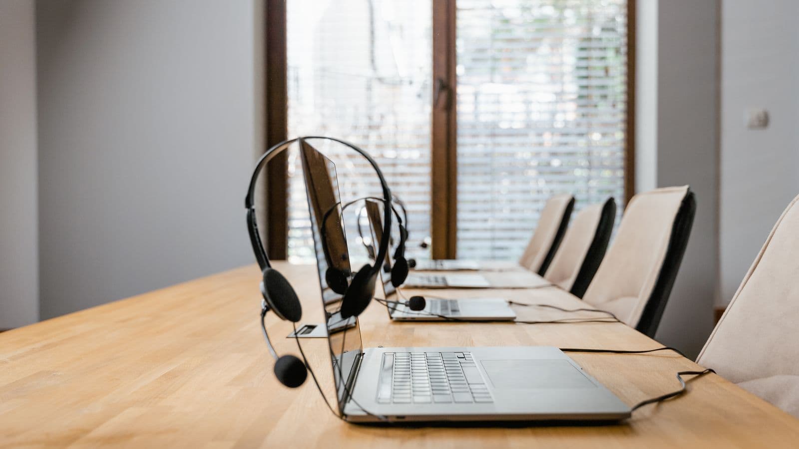 Headphones next to a laptop on a wooden table